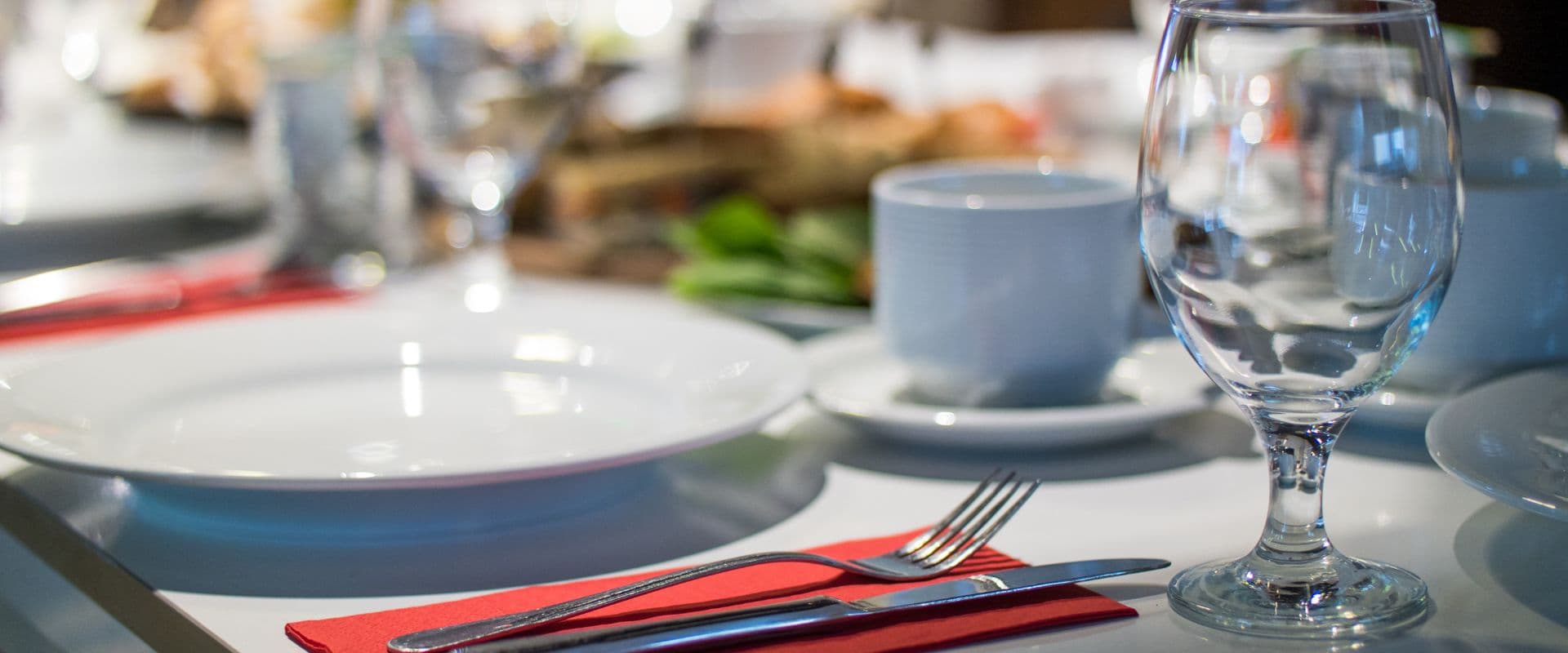 A neatly arranged dining table with plates, utensils, and glassware.